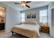 Bedroom features a comfortable bed, two windows and a ceiling fan at 7712 Bandon Cliffs St, North Las Vegas, NV 89084