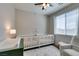 Bright Bedroom featuring two white cribs, a changing table, and a cozy armchair at 7712 Bandon Cliffs St, North Las Vegas, NV 89084