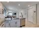 Open-concept kitchen featuring granite countertops, stainless steel appliances, and island with sink overlooking the living space at 7712 Bandon Cliffs St, North Las Vegas, NV 89084