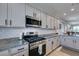 Modern kitchen featuring stainless steel appliances, granite countertops and white cabinets with black hardware at 7712 Bandon Cliffs St, North Las Vegas, NV 89084