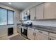 Well-lit kitchen featuring modern appliances, granite countertops, white cabinets, and tile backsplash at 7712 Bandon Cliffs St, North Las Vegas, NV 89084