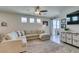Bright living room with a spacious sectional sofa, neutral rug, and sliding doors that brighten the space at 7712 Bandon Cliffs St, North Las Vegas, NV 89084