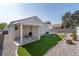 Beautifully landscaped backyard with synthetic grass and desert landscaping at 7828 Morning Flower Ln, Las Vegas, NV 89129