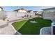 Landscaped backyard featuring artificial turf, desert plants, and a low wall around the perimeter at 7828 Morning Flower Ln, Las Vegas, NV 89129
