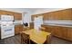 Bright eat in kitchen with wood cabinets, white appliances, and wood floors at 7828 Morning Flower Ln, Las Vegas, NV 89129