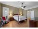 Spacious bedroom with wood floors, a four post bed frame and ample natural light at 7828 Morning Flower Ln, Las Vegas, NV 89129