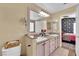Bathroom with dual sinks, a large mirror, and a view into the bedroom; great for families at 7845 Scammons Bay Ct, Las Vegas, NV 89129