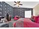 Bedroom with flower-themed wallpaper, ceiling fan, and comfortable furnishings for a relaxing ambiance at 7845 Scammons Bay Ct, Las Vegas, NV 89129