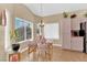 Charming dining area with a glass-top table, plush chairs, and bright natural light from the windows at 7845 Scammons Bay Ct, Las Vegas, NV 89129