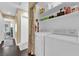 Bright laundry room featuring white washer and dryer, open shelving, and neutral tones at 7845 Scammons Bay Ct, Las Vegas, NV 89129