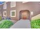 Charming condo entrance with decorative iron door, manicured shrubs, and adjacent air conditioning unit at 7950 W Flamingo Rd # 1044, Las Vegas, NV 89147