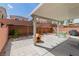View of the backyard featuring a covered patio, brick pavers, grilling area, and dog house at 8117 Discovery Point St, Las Vegas, NV 89139