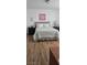 Cozy bedroom with wood floors, featuring a plush bed, decorative artwork, and bedside tables with lamps at 8117 Discovery Point St, Las Vegas, NV 89139