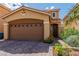 Charming single-Gathering home showcasing desert landscaping, a two-car garage and a quaint arched entryway at 8117 Discovery Point St, Las Vegas, NV 89139