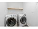 Convenient laundry room features a floating shelf and modern front-load machines at 8117 Discovery Point St, Las Vegas, NV 89139