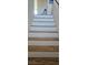 A well-lit staircase featuring light-colored risers and wood treads, leading to the next level of the home at 8117 Discovery Point St, Las Vegas, NV 89139