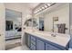 Bright bathroom featuring double sinks, large mirror, and adjacent bedroom view at 8628 Desert Holly Dr, Las Vegas, NV 89134