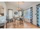 Cozy dining area featuring wood floors, chandelier lighting, and patterned curtains that frame the window at 8628 Desert Holly Dr, Las Vegas, NV 89134
