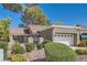 Charming single-story home featuring a red tile roof, attached garage, and lush landscaping at 8628 Desert Holly Dr, Las Vegas, NV 89134