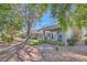 Exterior view of a townhome community featuring a covered patio and mature trees at 8628 Desert Holly Dr, Las Vegas, NV 89134