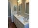 Bathroom featuring double sink, white cabinets, marble countertop and two large framed mirrors at 8641 Surtidor Dr, Las Vegas, NV 89117