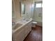 Bright bathroom featuring double sinks, white cabinets, and wood-look flooring at 8641 Surtidor Dr, Las Vegas, NV 89117