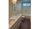 Bathroom featuring double sinks with marble counters, framed mirrors, and wood-look flooring at 8641 Surtidor Dr, Las Vegas, NV 89117
