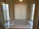 Bathtub featuring white countertops and tile backsplash and three large windows at 8641 Surtidor Dr, Las Vegas, NV 89117