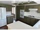 View of kitchen with green cabinets, white appliances, white countertops, and wood floors at 8641 Surtidor Dr, Las Vegas, NV 89117