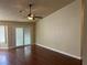 Bright living room with hardwood floors, a ceiling fan, and sliding glass doors leading to the outside at 8641 Surtidor Dr, Las Vegas, NV 89117