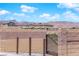 View of the community, framed by a wall and gate, with mountains visible in the distance at 9176 Bluebell Knoll Ct, Las Vegas, NV 89178