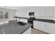 Contemporary kitchen with white cabinetry, dark countertops, and modern appliances at 9176 Bluebell Knoll Ct, Las Vegas, NV 89178
