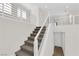 Carpeted staircase with modern white and steel railings leading to the upper level of the home at 9176 Bluebell Knoll Ct, Las Vegas, NV 89178