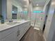 Bright bathroom featuring double vanity, large mirror, and a glass-enclosed shower at 928 Woodburn Ln, Las Vegas, NV 89138