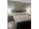 Bedroom featuring a bed with end tables on laminate wood flooring at 9325 W Desert Inn Rd # 174, Las Vegas, NV 89117
