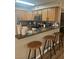 Kitchen view with warm wood cabinets, stainless steel appliances, and a breakfast bar with stools at 9325 W Desert Inn Rd # 174, Las Vegas, NV 89117