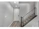 Modern entryway featuring light gray walls, wood-look flooring, and a staircase with metal railing at 10160 W Meranto Ave, Las Vegas, NV 89178