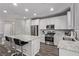 Bright kitchen boasts an island with seating, white cabinets, and stainless steel appliances at 10160 W Meranto Ave, Las Vegas, NV 89178