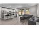 Open-concept living area with sleek floors, a kitchen island, and sliding glass doors to the backyard at 10160 W Meranto Ave, Las Vegas, NV 89178