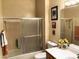 Well-lit bathroom featuring a shower with sliding doors, toilet, and vanity with mirror at 11031 Mission Lakes Ave, Las Vegas, NV 89134