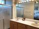 Bright bathroom featuring a double vanity, stained glass window, and shower with glass doors at 11031 Mission Lakes Ave, Las Vegas, NV 89134