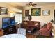 Bright living area featuring comfortable sofas, large windows, and a ceiling fan at 11031 Mission Lakes Ave, Las Vegas, NV 89134