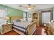 Bedroom showcasing a bed with light green walls, wood floors and ample natural light at 11620 Longhirst Hall Ln, Las Vegas, NV 89138