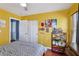 Bedroom with yellow walls, wood floors, and closet space at 11620 Longhirst Hall Ln, Las Vegas, NV 89138