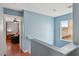 Upstairs hallway view leads to a comfortably furnished living room at 11620 Longhirst Hall Ln, Las Vegas, NV 89138
