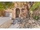 Inviting entryway with an arched front door, decorative planters, and attractive desert landscaping at 11673 Pride Hill St, Las Vegas, NV 89183