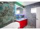 Modern bathroom featuring green textured wall, dual vanity, pebble floor, and accent lighting for a spa-like experience at 120 Chartan Ave, Las Vegas, NV 89183