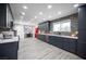 Kitchen featuring modern dark cabinetry, a window, a breakfast bar, and stainless steel appliances at 120 Chartan Ave, Las Vegas, NV 89183