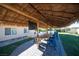 Spacious outdoor dining area featuring a tiki roof, TV, and large table, perfect for entertaining guests and enjoying the backyard at 120 Chartan Ave, Las Vegas, NV 89183