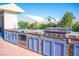 Well-equipped outdoor kitchen featuring a built-in grill, stone accents, and blue cabinets, perfect for outdoor gatherings and BBQs at 120 Chartan Ave, Las Vegas, NV 89183
